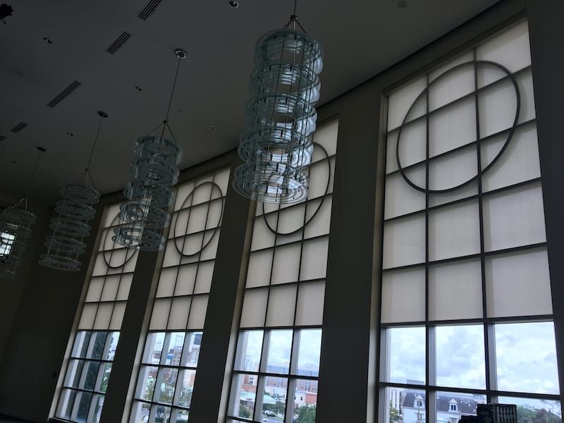 Tall windows with circular and grid designs. Hanging glass chandeliers.