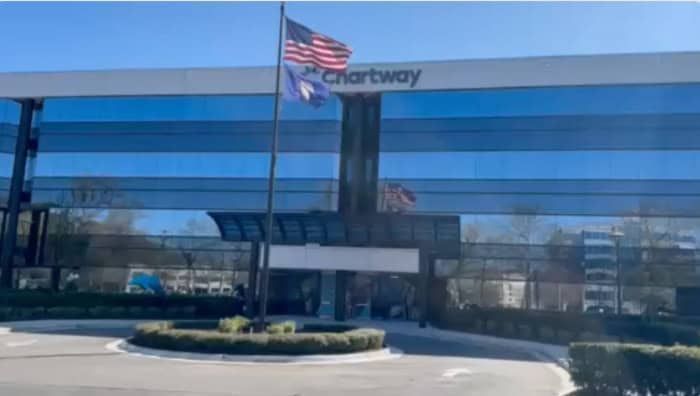Chartway building with a US and state flag waving on a sunny day.