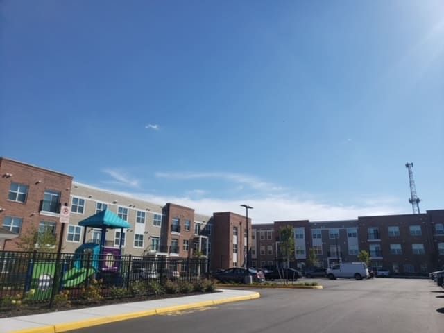 Apartment complex with a playground and blue sky.
