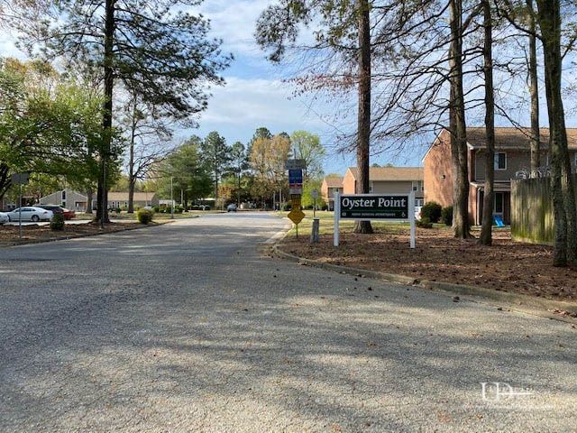 Entrance to Oyster Point community with a sign and a road.