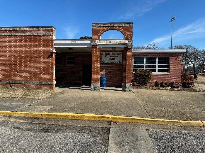 Brick building with arched entrance and sign reading 