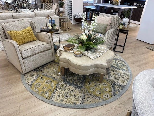Living room with upholstered chairs and a patterned rug around an ottoman.
