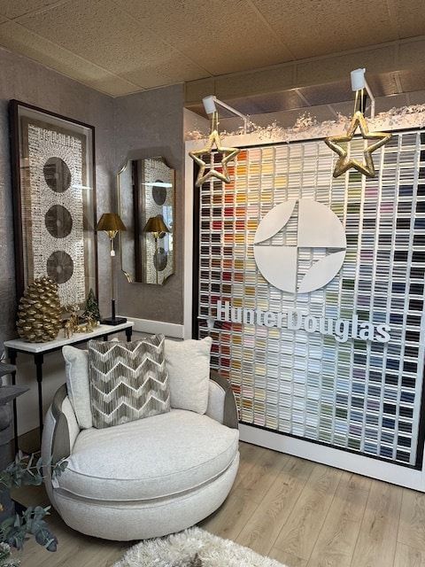 Interior showroom with Hunter Douglas display, round chair, mirrors, and decorative accents.