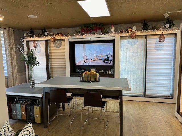 Interior room with a table and chairs in front of a wall with a TV and blinds.