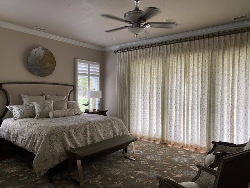 Elegant bedroom with bed, sheer curtains, and area rug.