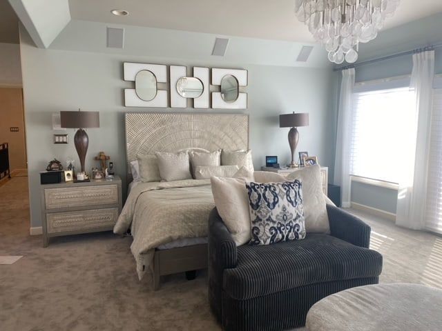 Bedroom with light blue walls, gray furniture, and large windows.