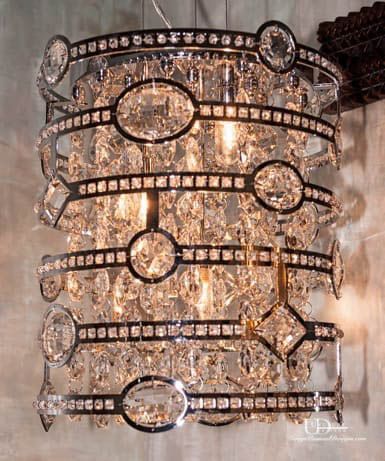 Crystal and chrome chandelier with decorative metal bands and numerous clear crystals.