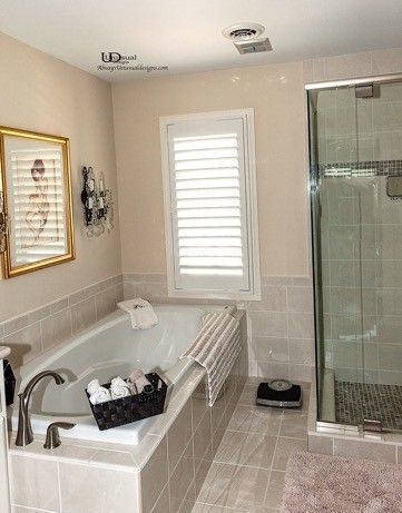 Bathroom with bathtub, shower, window with shutters, and weight scale.