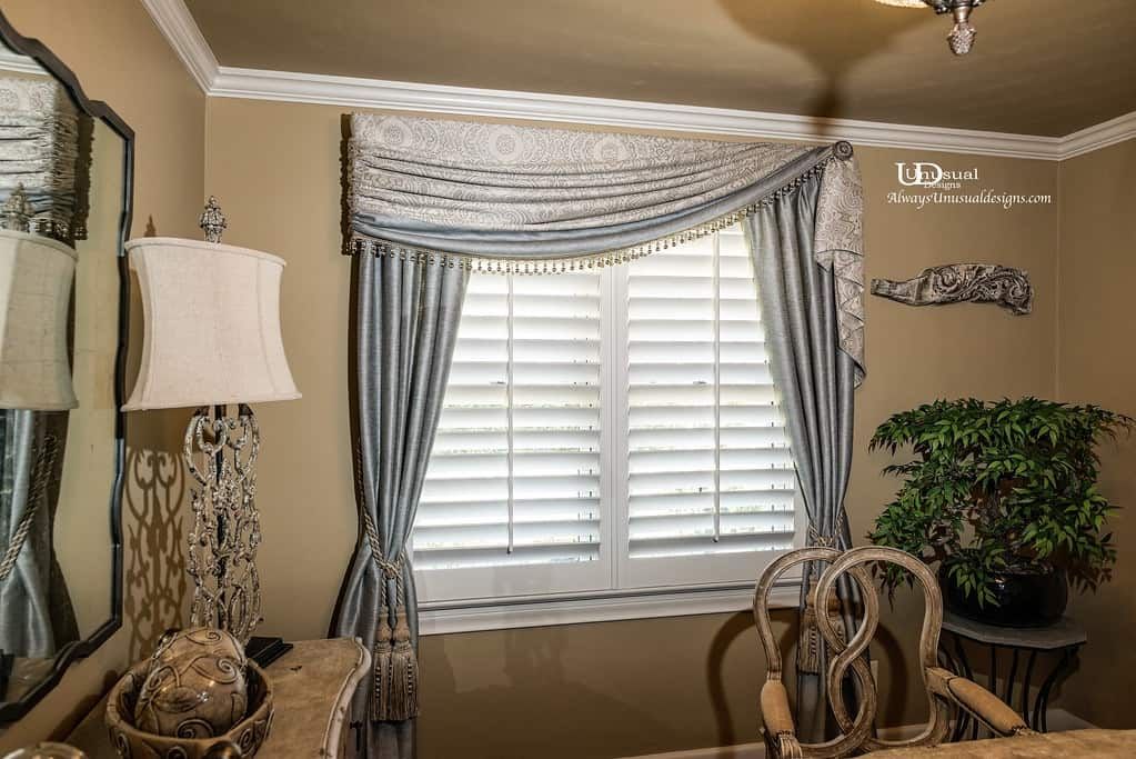 Interior with window, curtains, shutters, and decorative lamp. Light blue and beige color scheme.