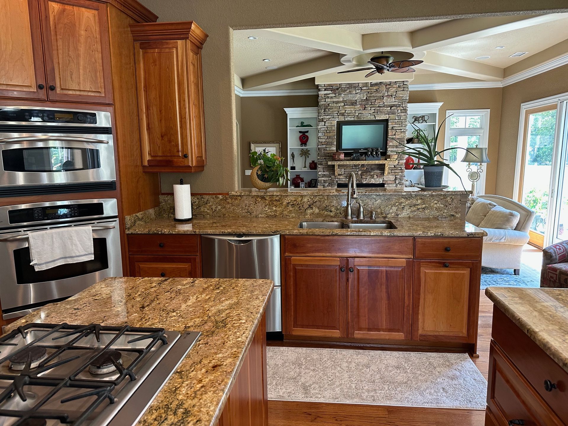 Kitchen with brown cabinets, granite countertops, and stainless steel appliances.
