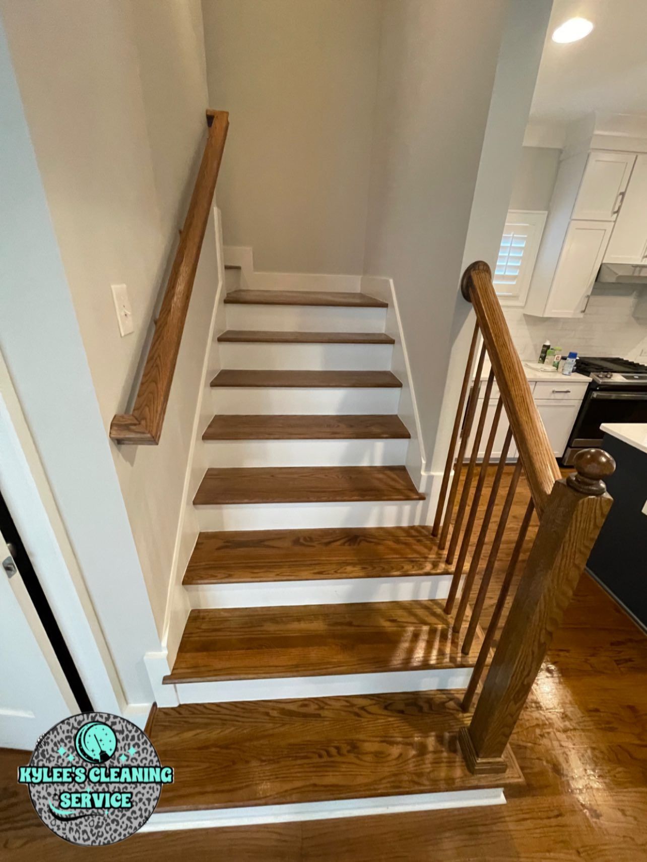 Wooden staircase with white risers and a wood railing in a home.