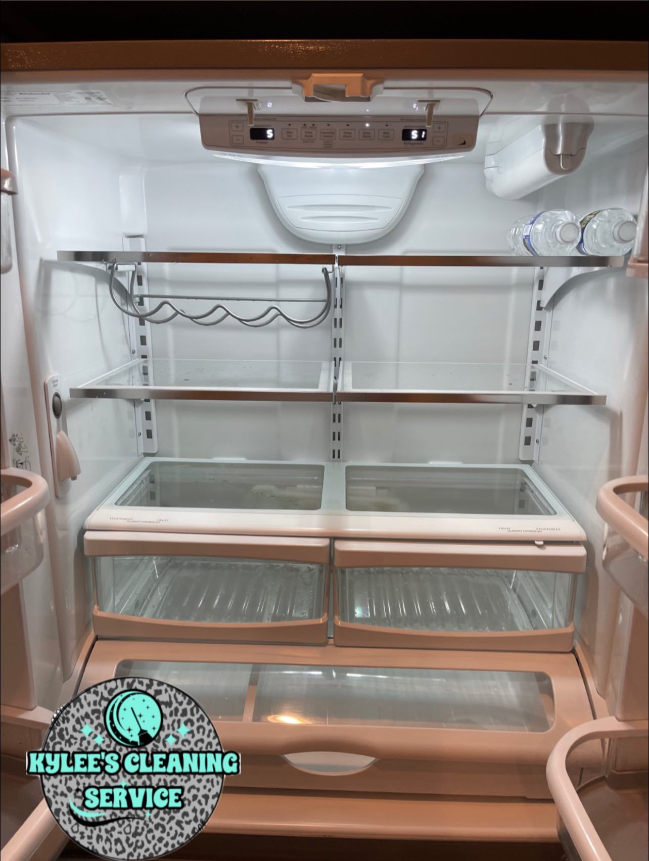 Empty refrigerator interior with adjustable shelves, crisper drawers, and bright lighting.