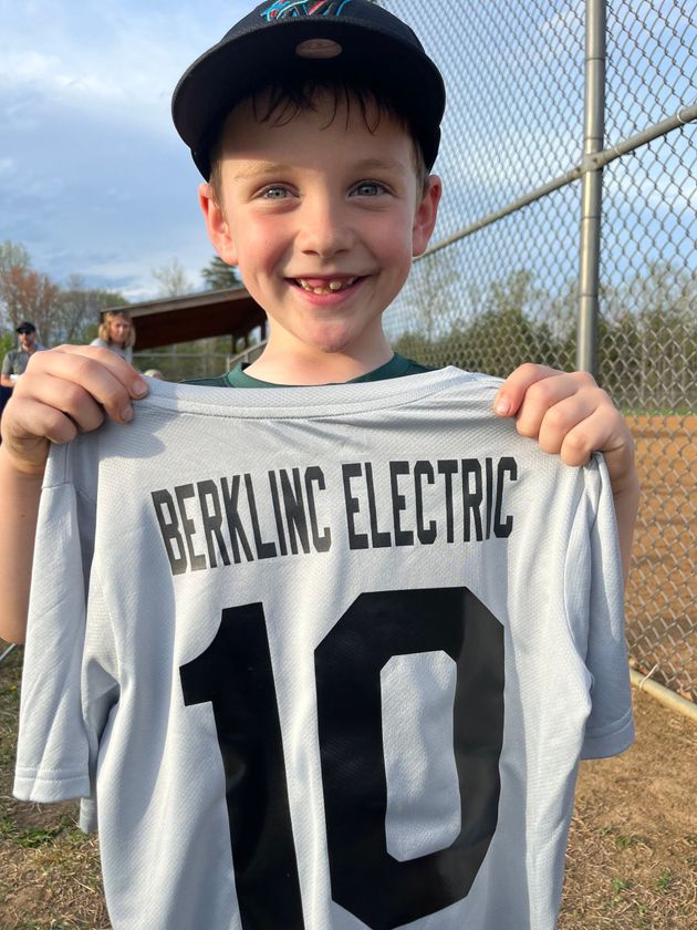 Boy holding up a gray jersey with