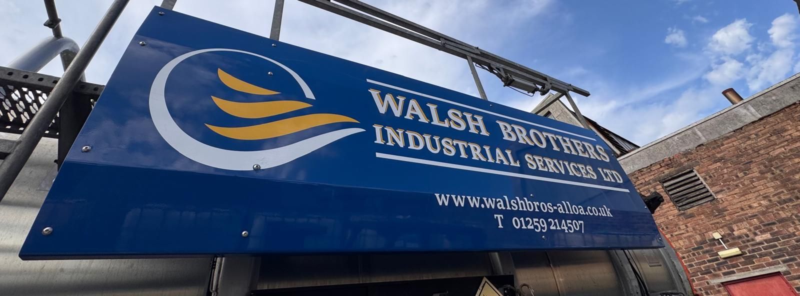 Blue sign for Walsh Brothers Industrial Services. It has their logo and website.