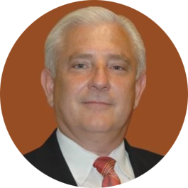 Portrait of a man in a dark suit and red tie against a brown background