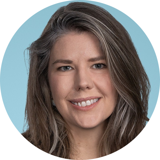 Headshot of a smiling person with shoulder-length brown hair on a light blue background