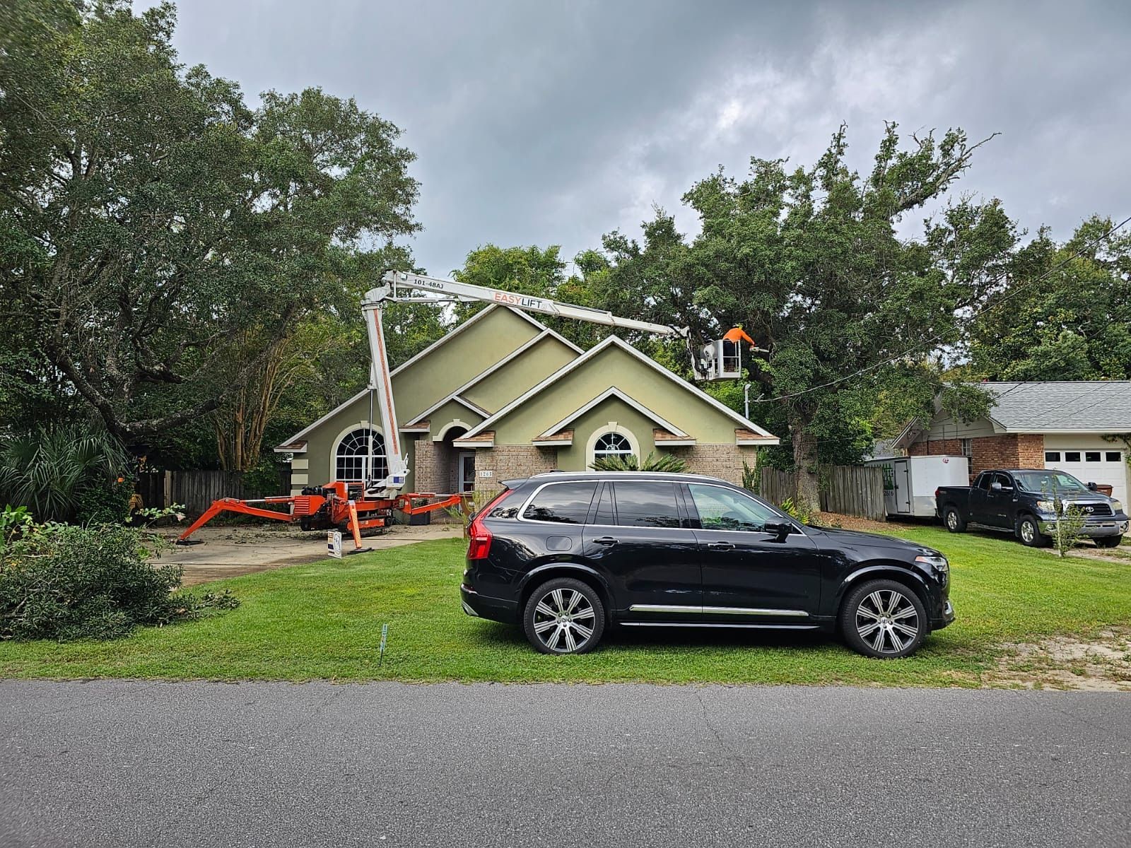A black suv is parked in front of a house.