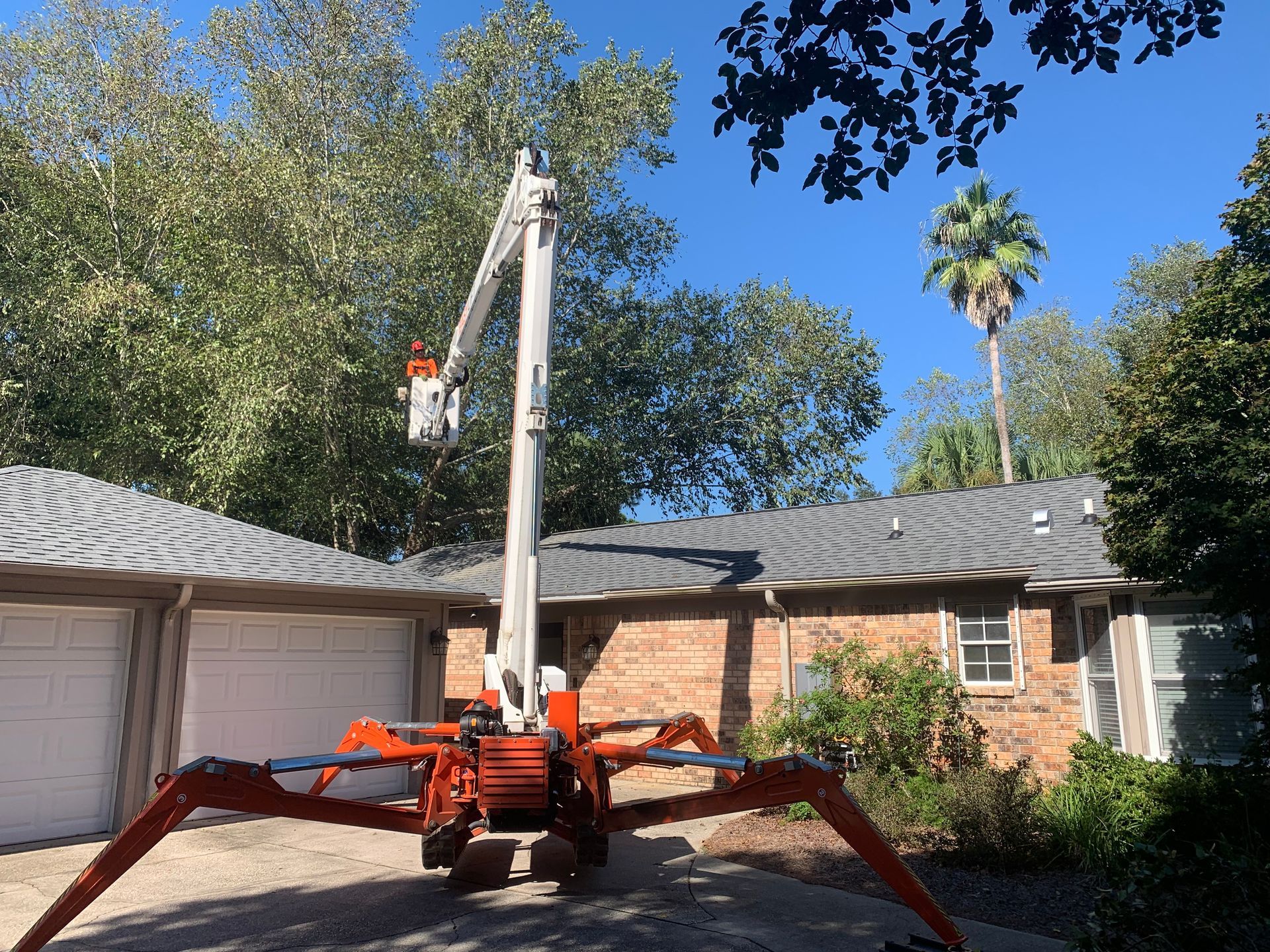 A spider lift is parked in front of a house.