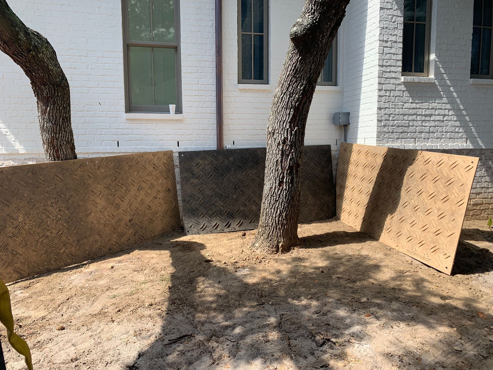 A white brick house with a tree in front of it