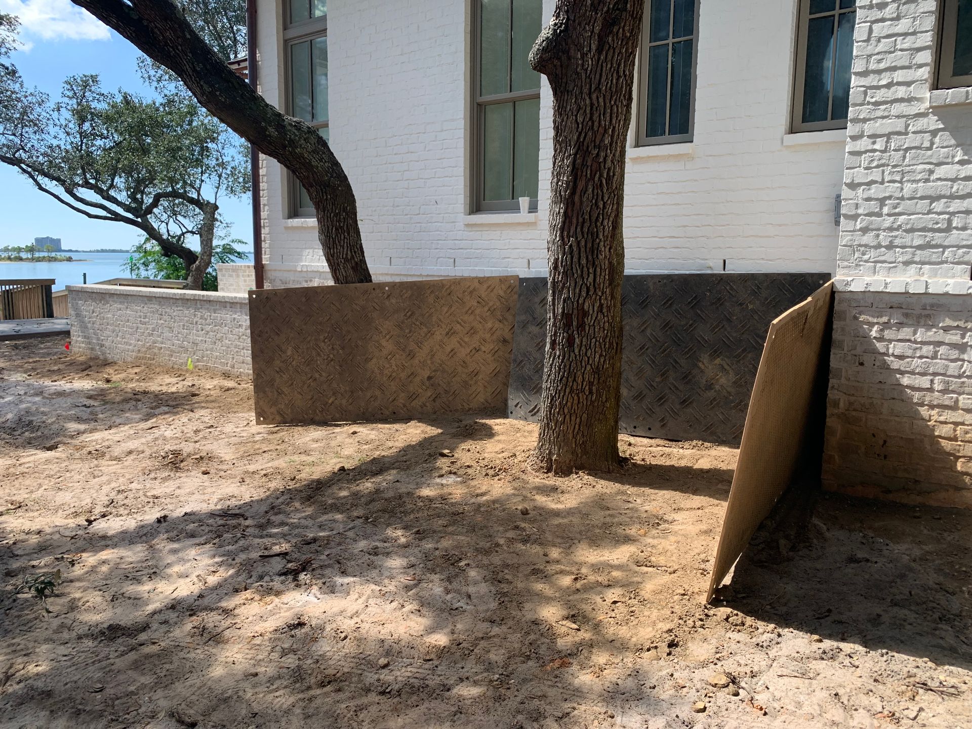 A white brick building with a tree in front of it