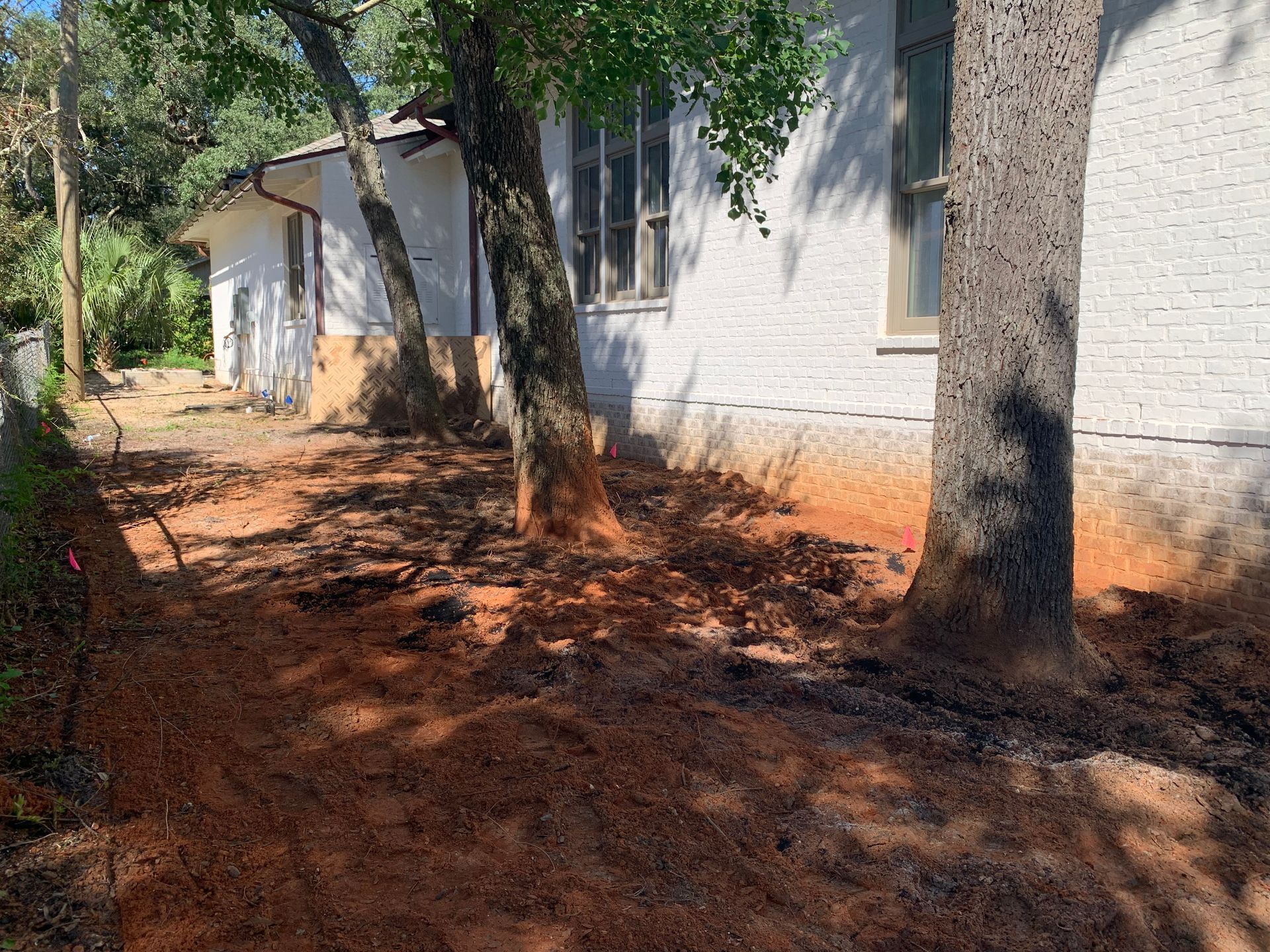 A white house with a lot of dirt in front of it.
