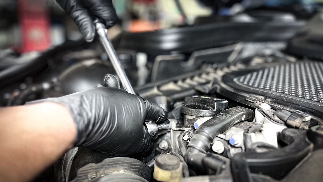 A mechanic working on a camshaft position sensor on a Mercedes | Gilroy Car Care