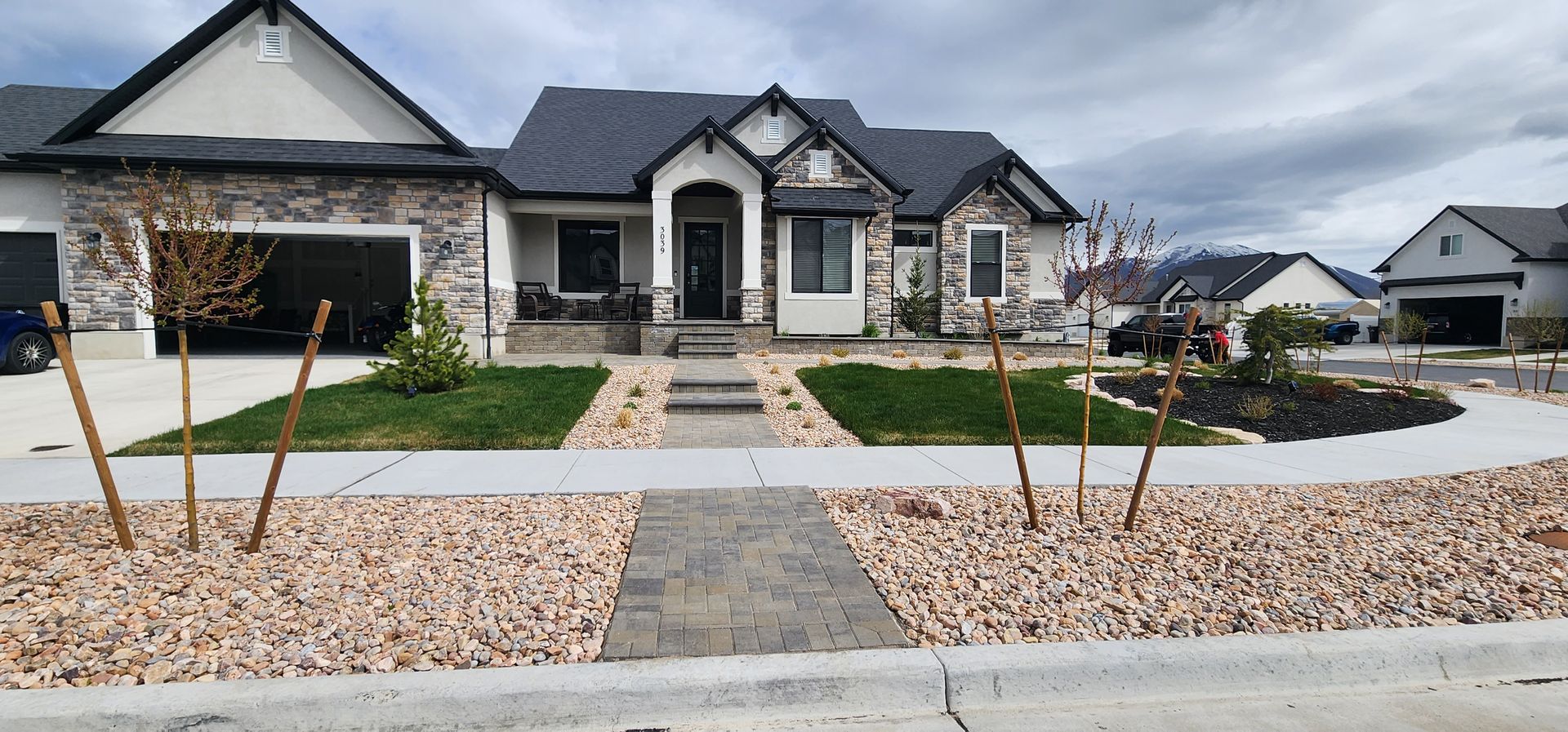 A large house with a gray roof is sitting on top of a lush green hillside.