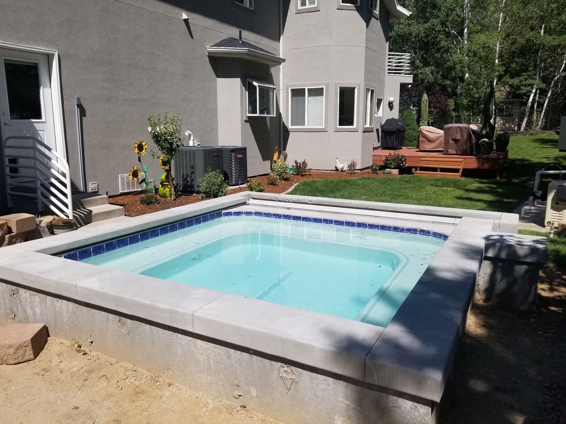 A swimming pool is being built in the backyard of a house