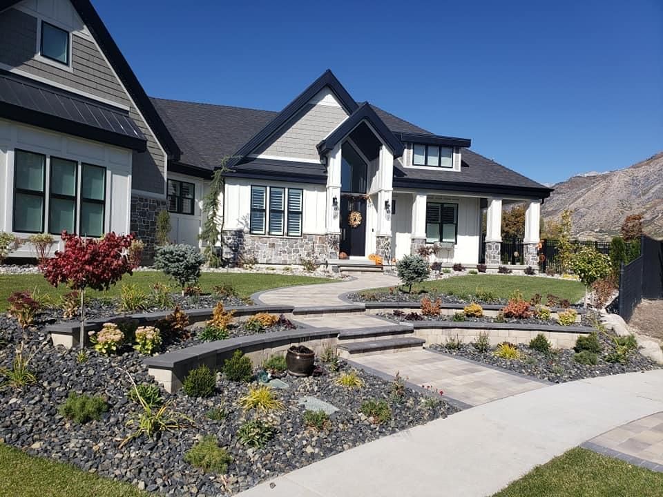 A large white house with a black roof and a walkway leading to it.