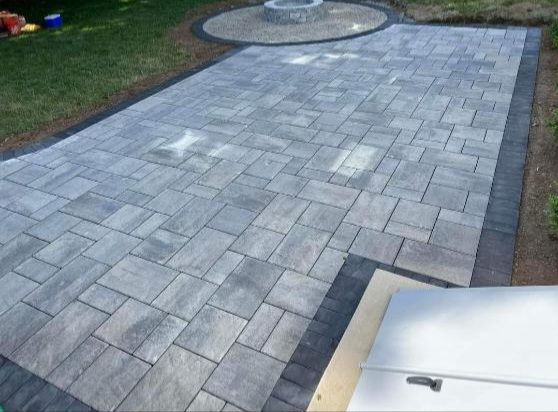 A patio with a fire pit in the middle of it.