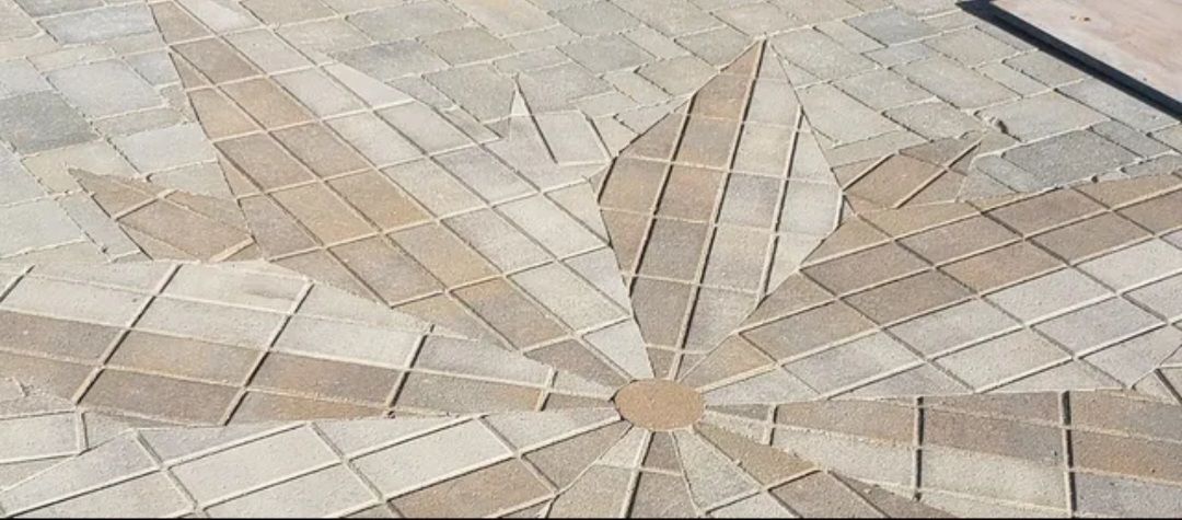 A close up of a circular pattern on a brick floor.