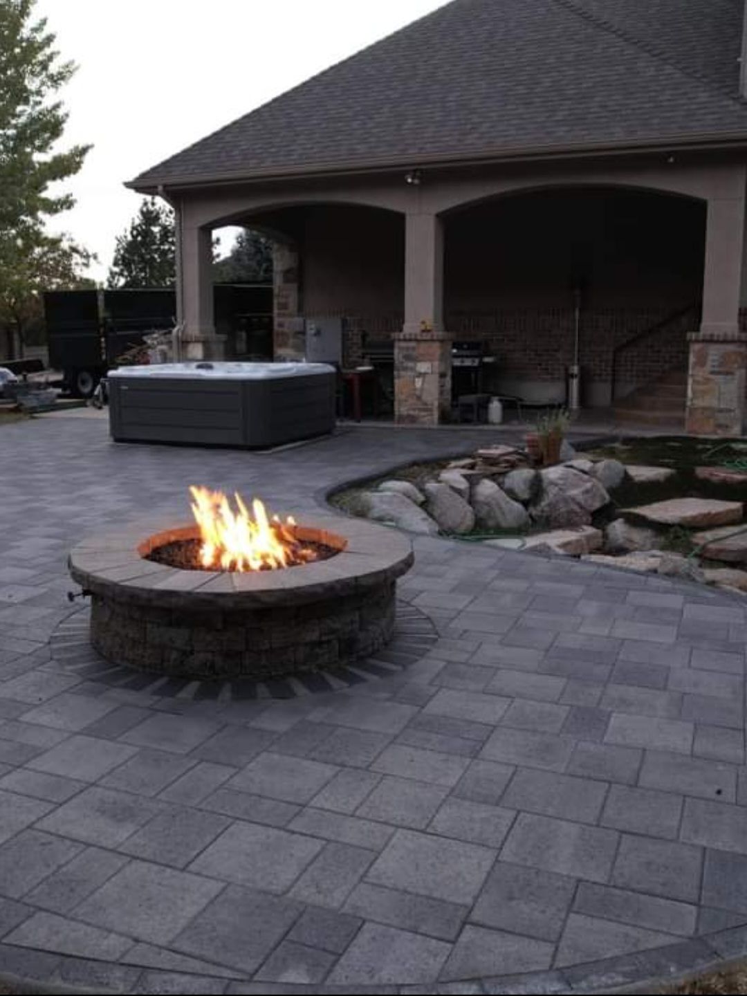 A fire pit with a hot tub in the background