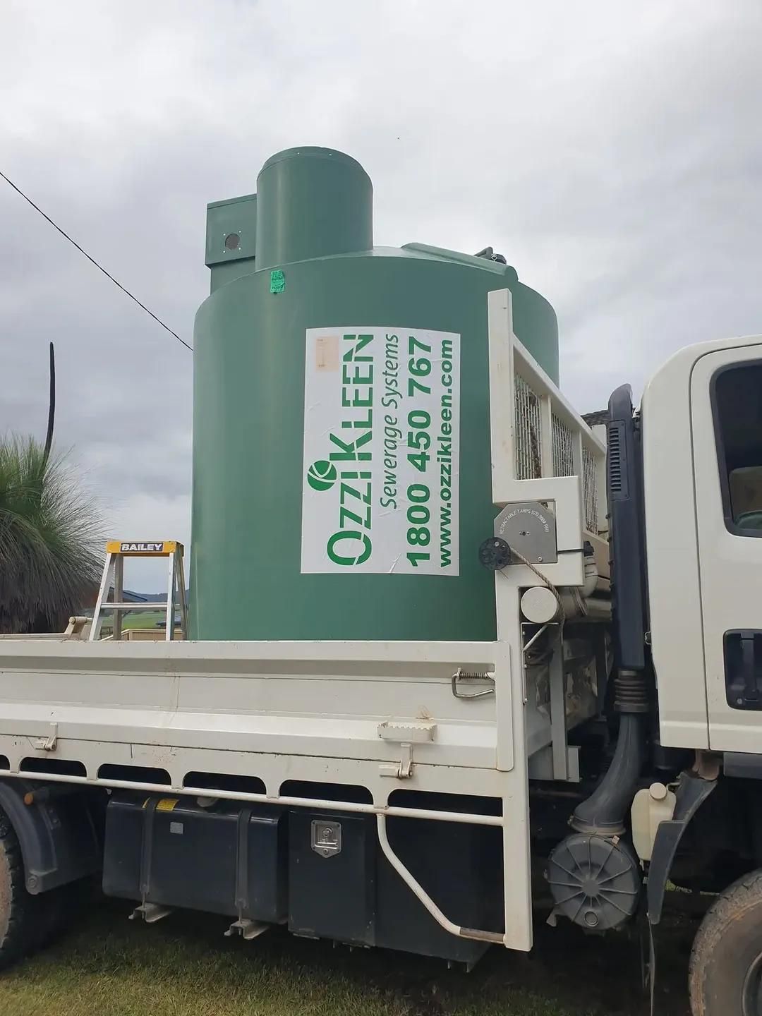 A White Truck with A Green Tank on The Back that Says Ozzikleen — Murwillumbah District Plumbing Service in Nunderi, NSW