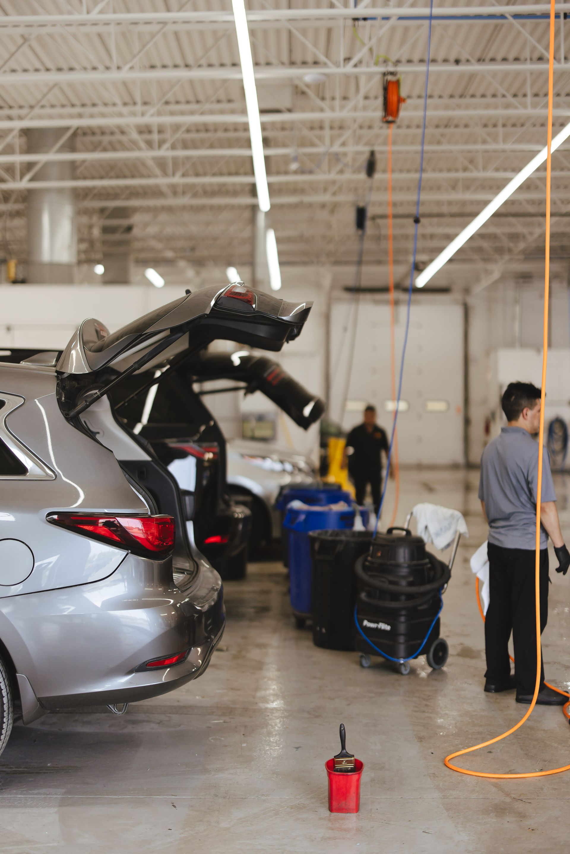 A man is polishing a car with a machine.