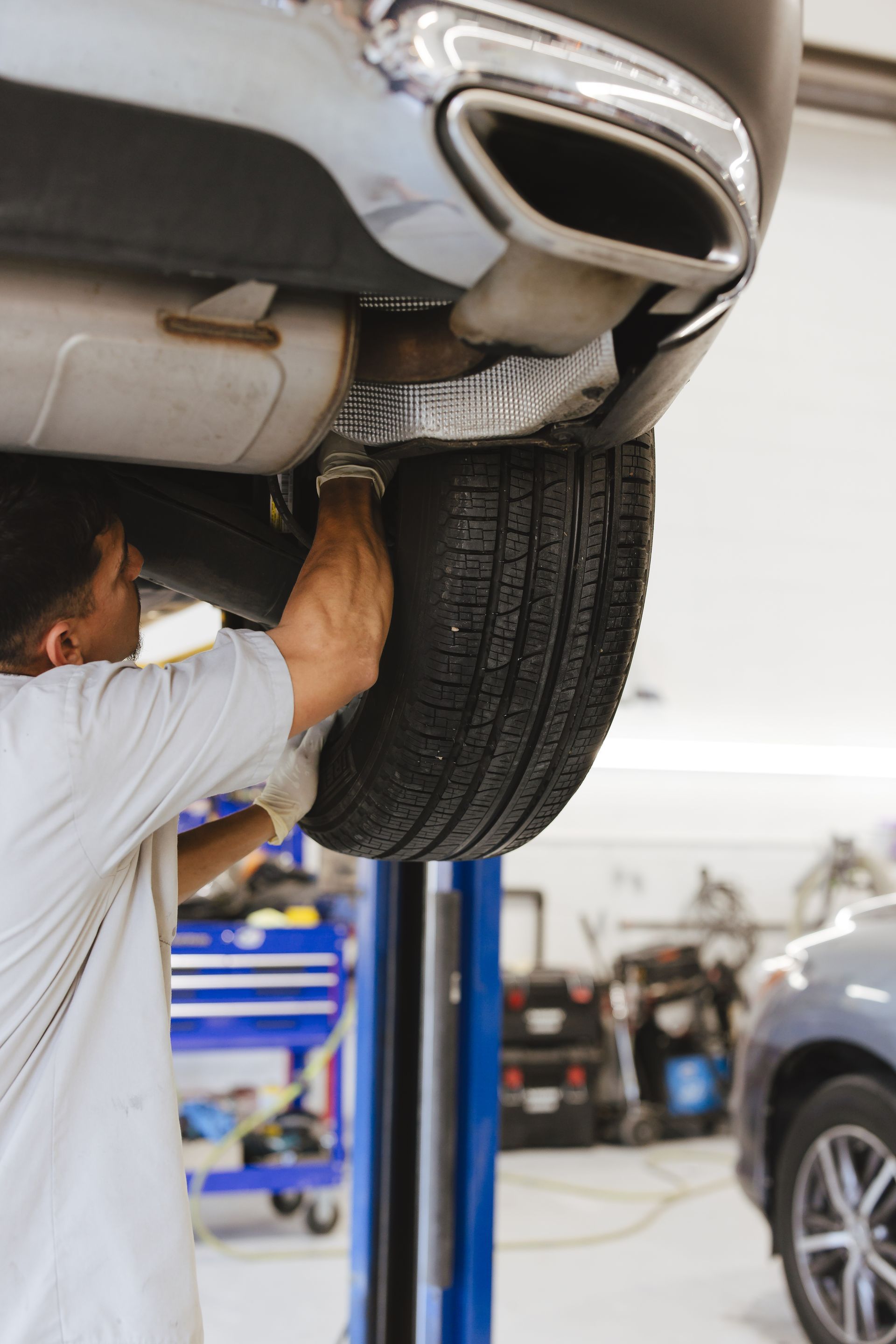 A man is working on a car engine with a wrench.