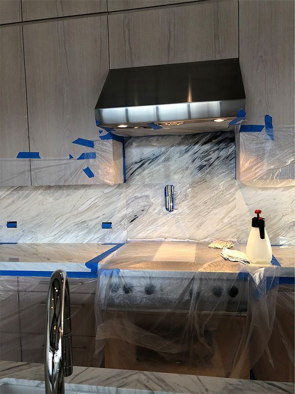 A kitchen that is being painted with blue tape