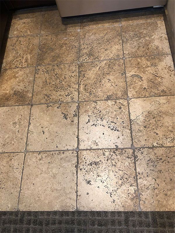 A close up of a tiled floor in a laundry room.