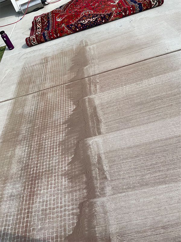 A rug is laying on top of a concrete floor.