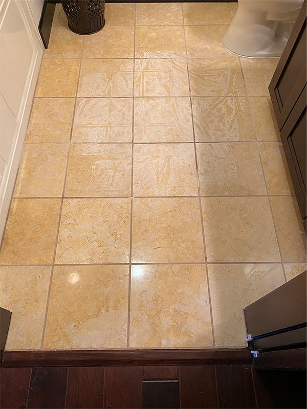 A bathroom with a tiled floor and a toilet.