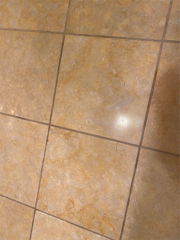 A close up of a tiled floor with a shadow on it.
