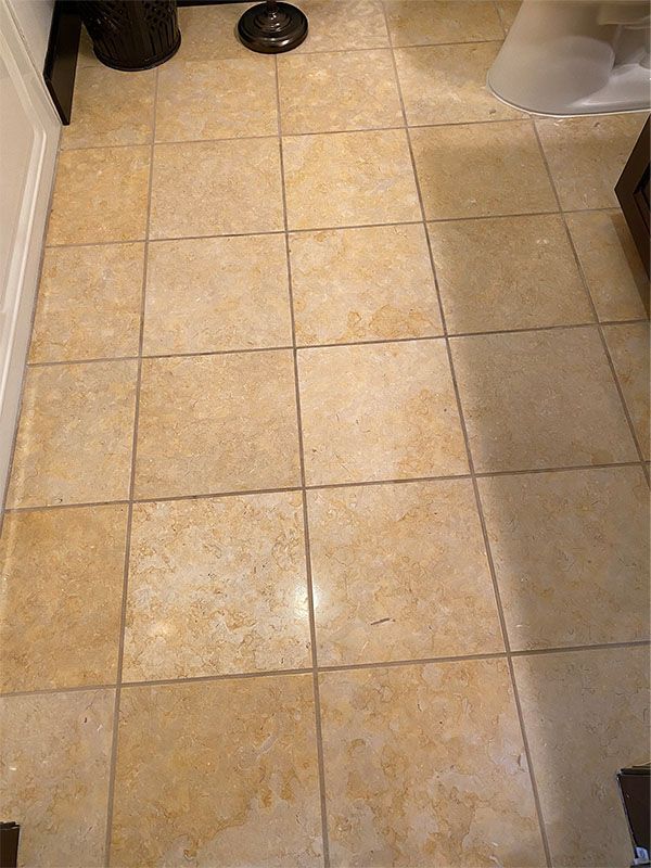 A tiled floor in a bathroom next to a toilet.