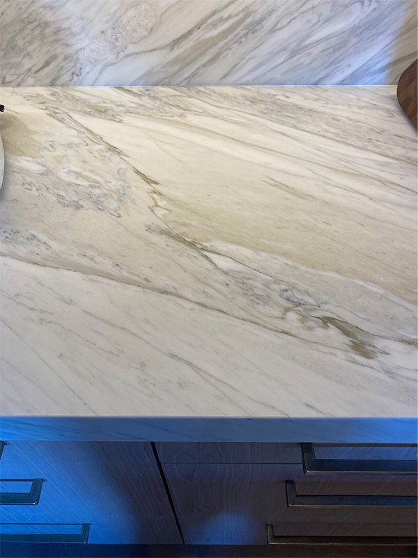 A close up of a white marble counter top in a kitchen.