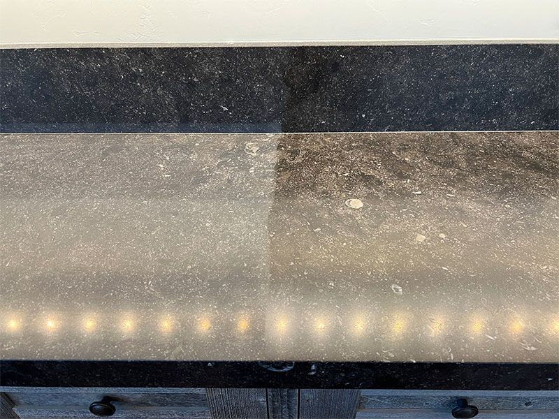 A close up of a dirty counter top with a light on it.