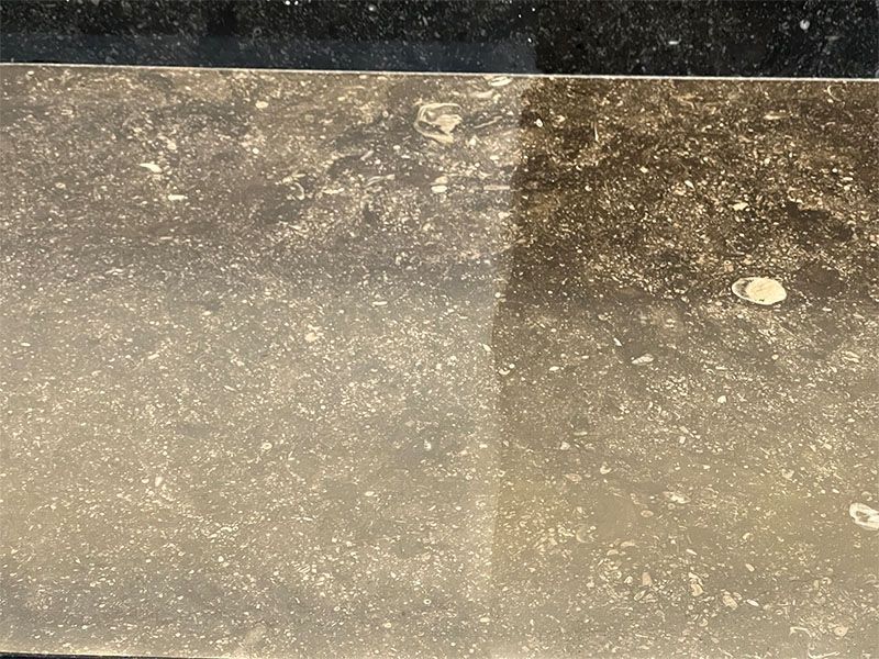 A close up of a dirty surface with a black background.