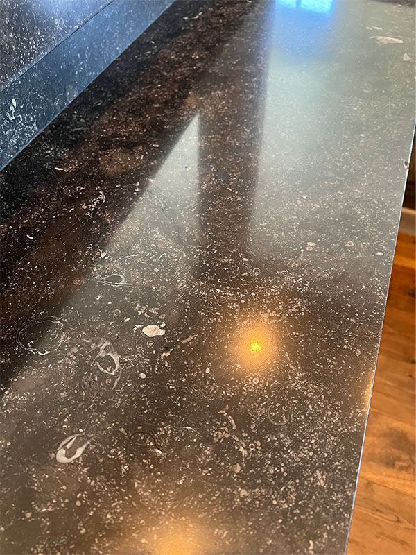 A close up of a black granite counter top in a kitchen.