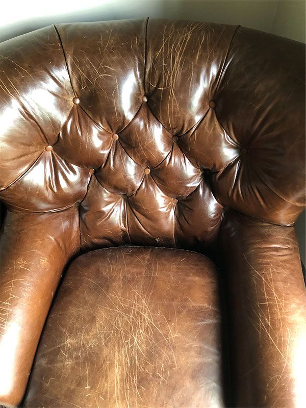A brown leather chair is sitting in a room.