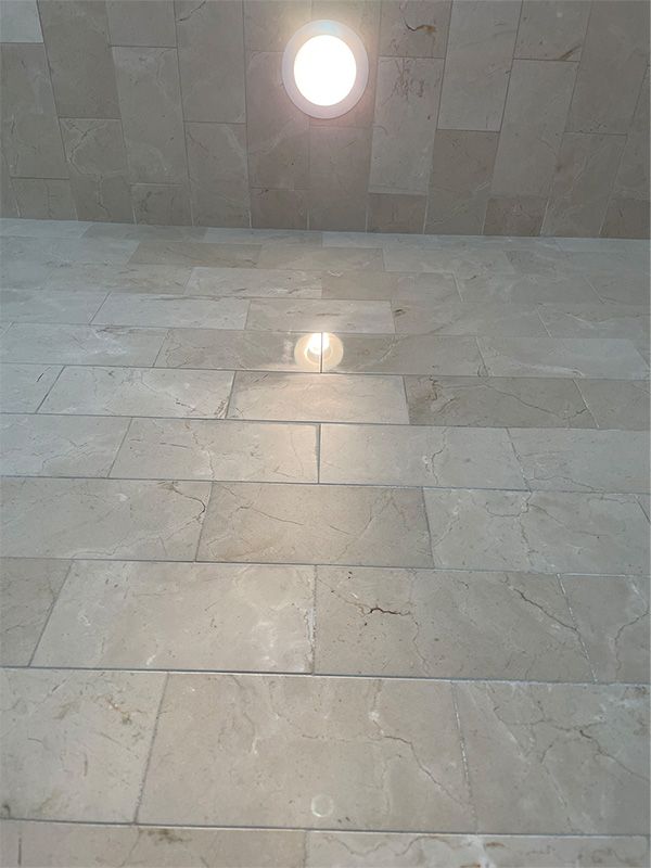 A light is shining on a tiled floor in a room.