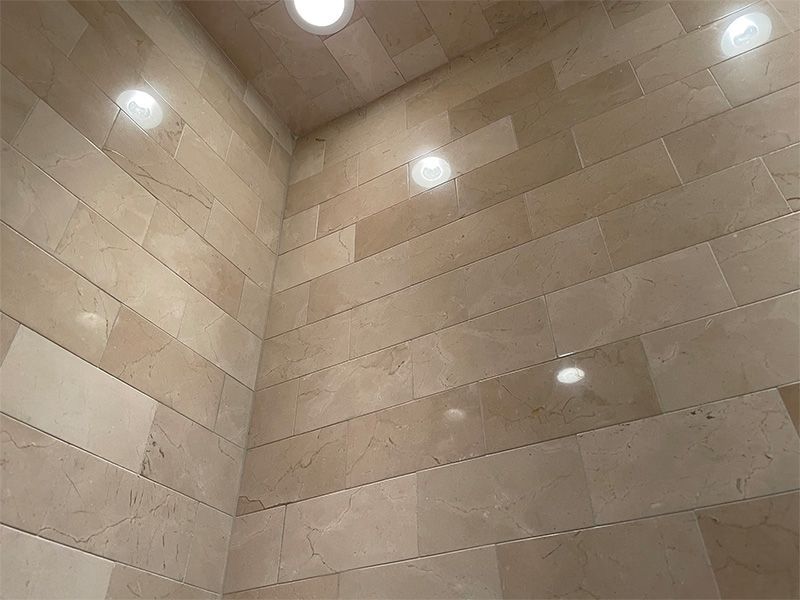 A bathroom with a lot of tiles on the wall and ceiling.