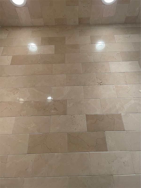 A close up of a tiled floor with two lights on the ceiling.