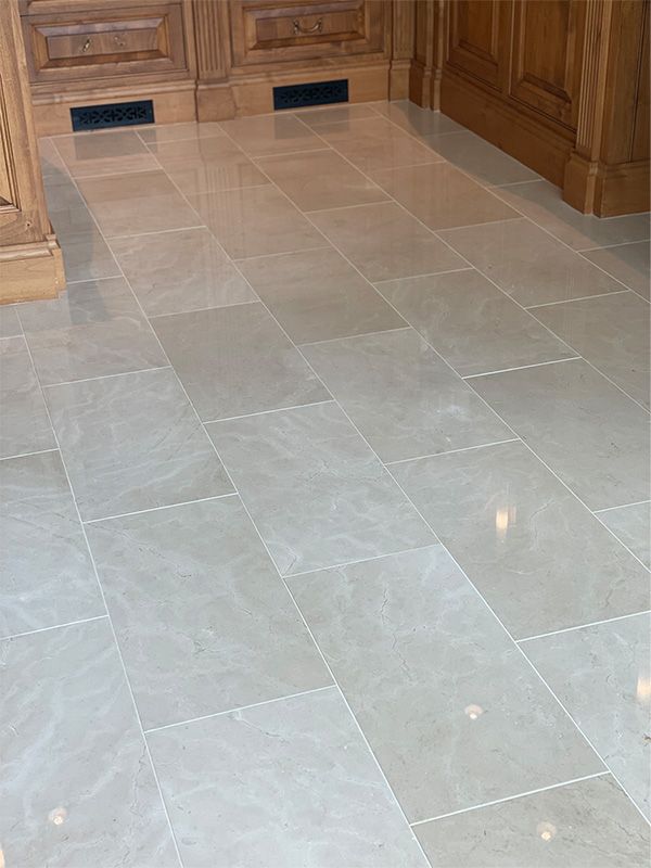 A kitchen with a tiled floor and wooden cabinets.